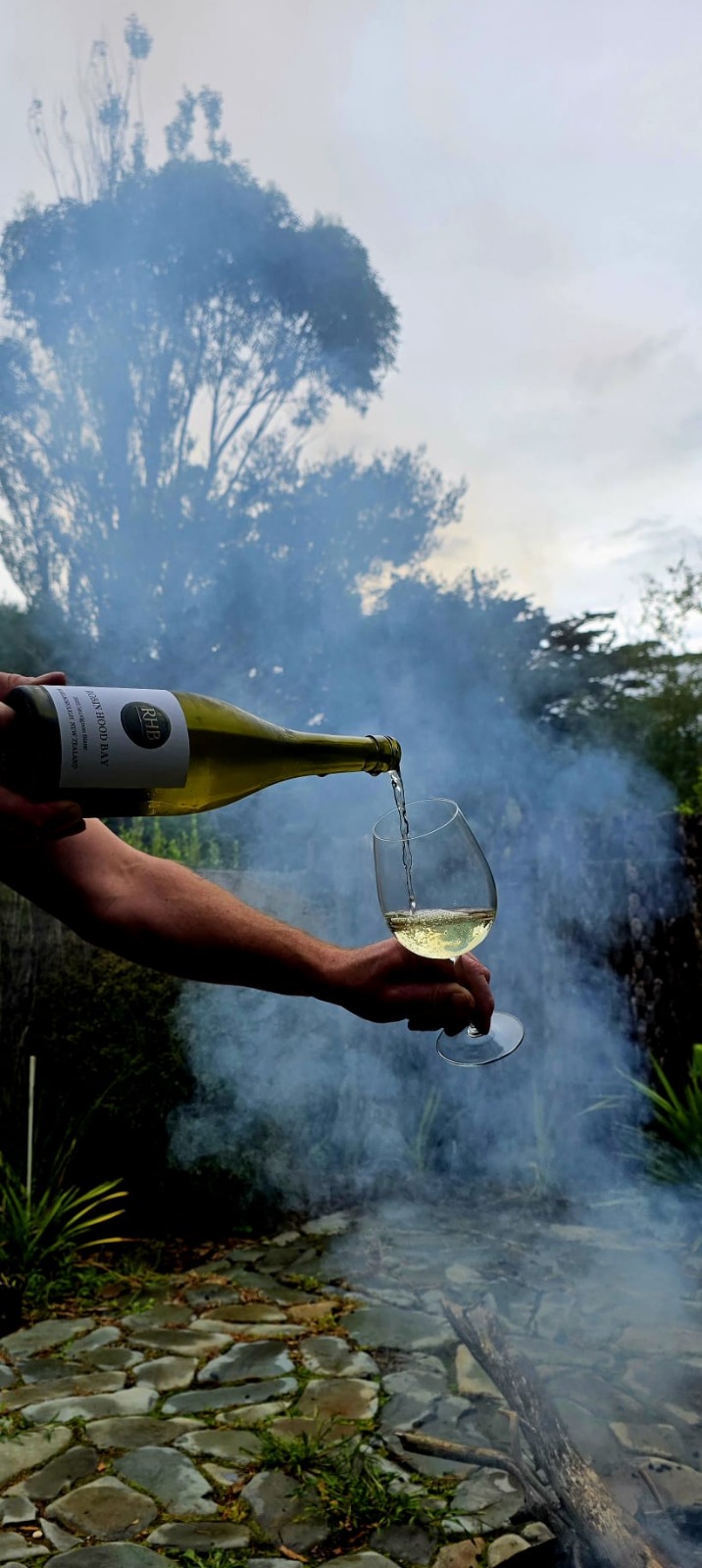 Wine being poured outdoors beside a fire